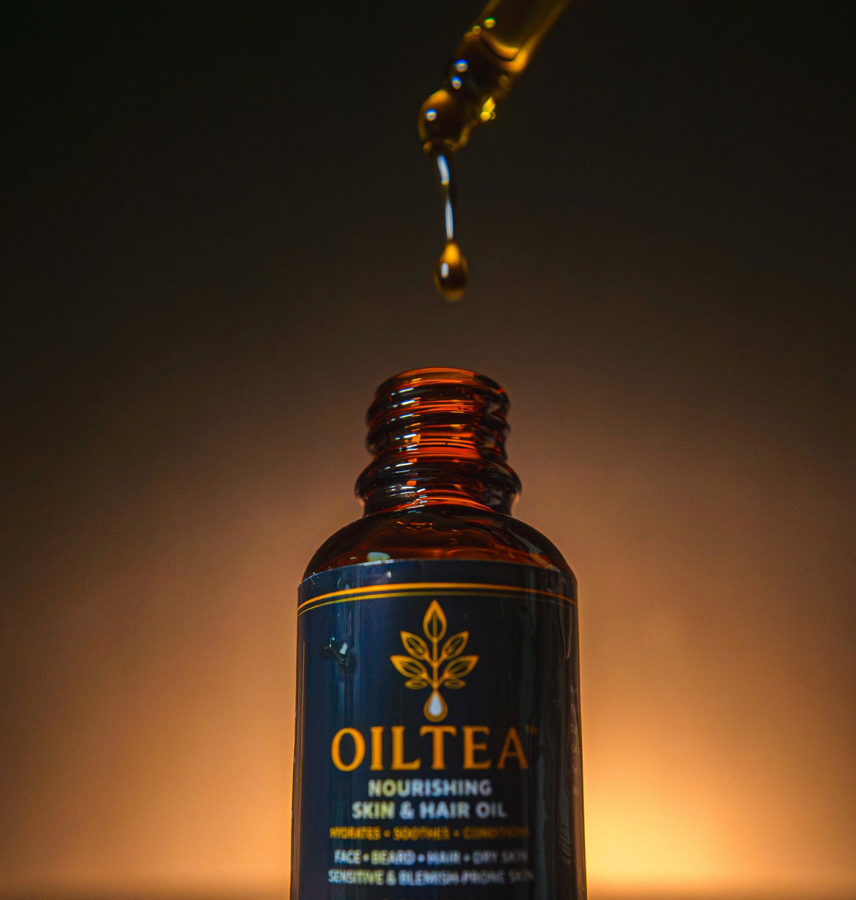 Drops of OILTEA oil falling from the dropper into the open bottle